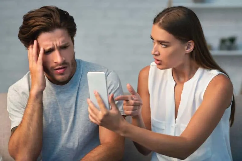 girlfriend showing her cheating boyfriend his cellphone