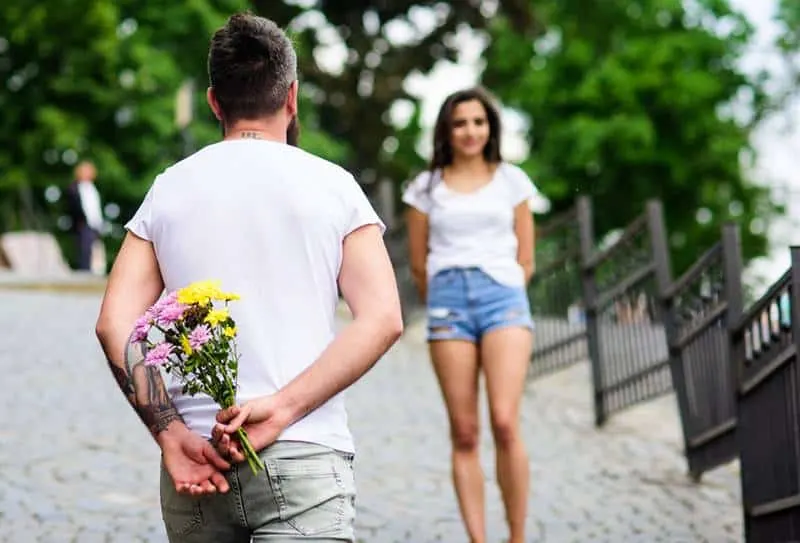 man holding flowers and waiting for girlfriend