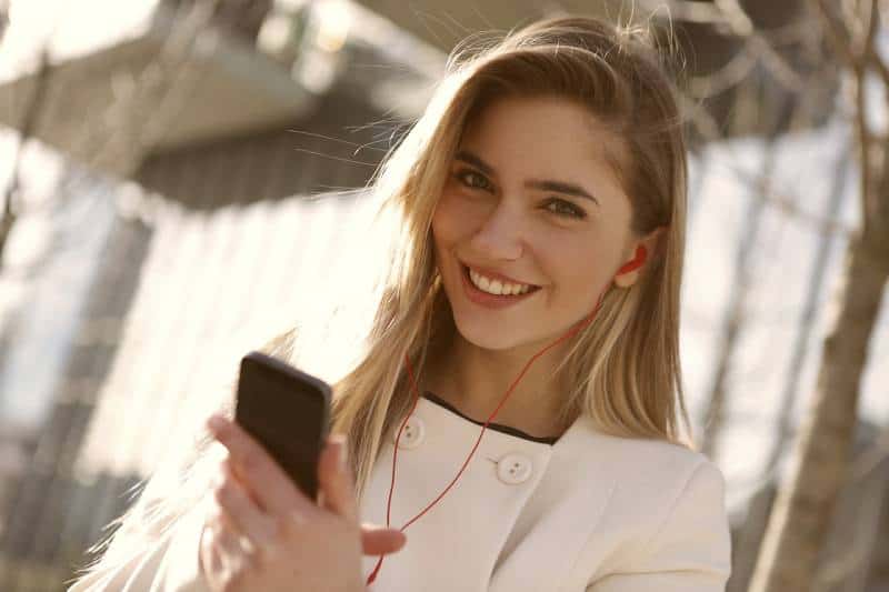 portrait of smiling girl typing her phone