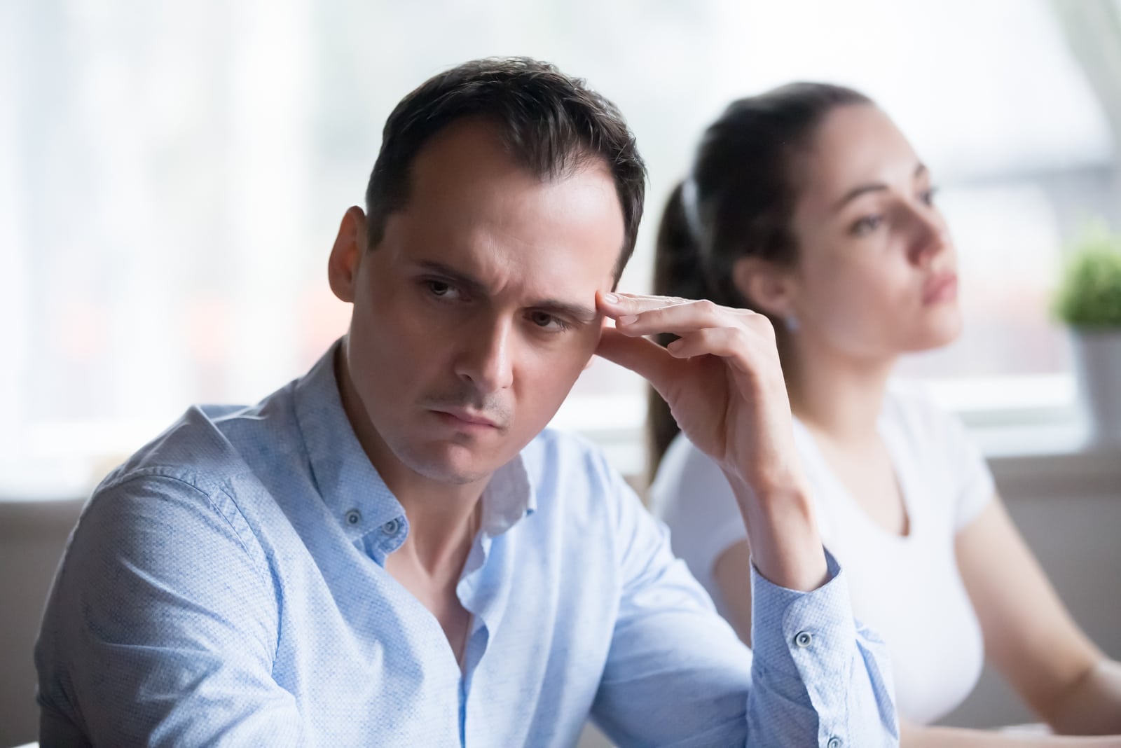 serious man looking away from woman