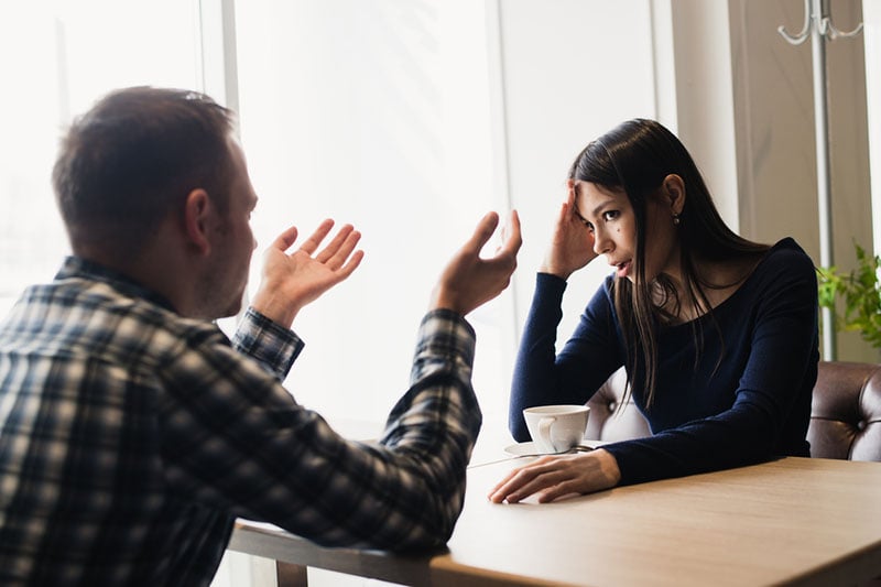 serious man talking to woman