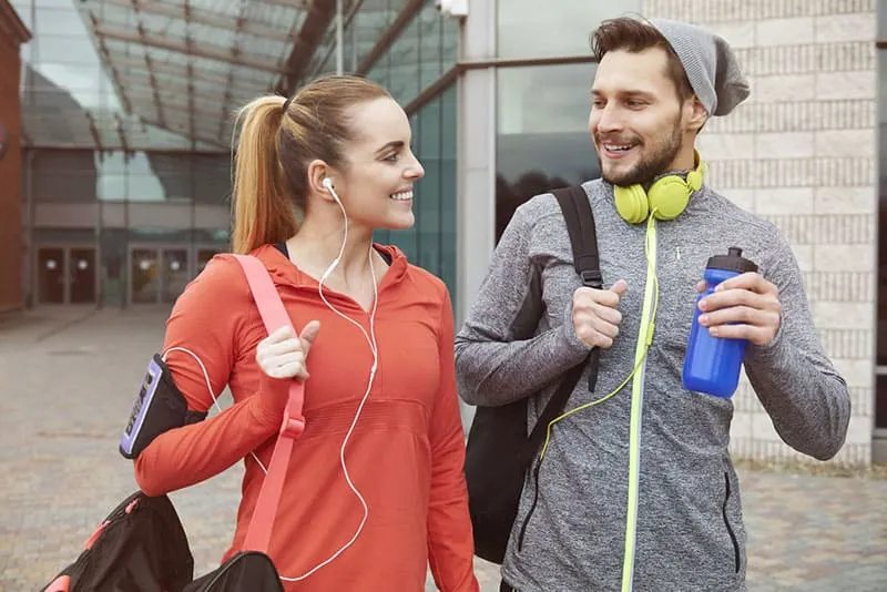 smiling couple walking to the gym