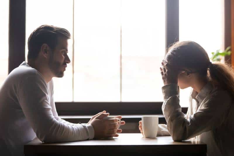 coppia sconvolta che parla in un caffè