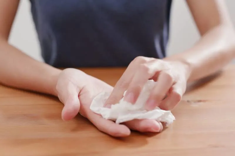 woman cleaning palms with paper