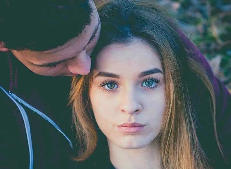 woman with blue eyes hugged by her boyfriend