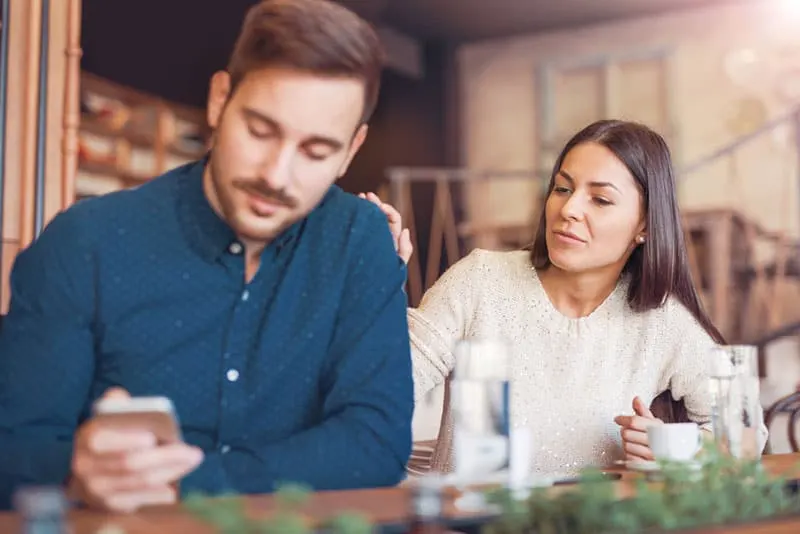 worried couple sitting at cafe