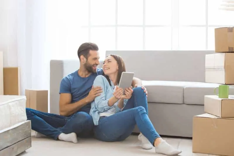 young couple in love sitting on floor at home and looking each other