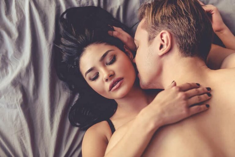 couple kissing in bed