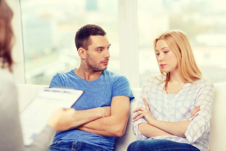 sad couple sitting at therapyst