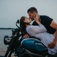 a man kisses a woman on a motorcycle