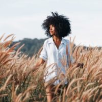 una mujer con el pelo encrespado en un campo de trigo
