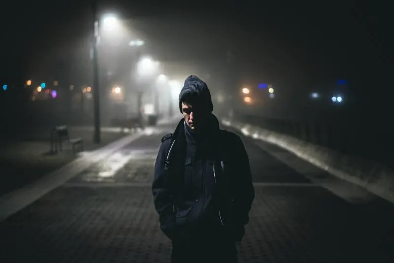 Man standing near street lamps during night