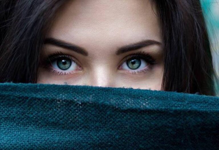 foto de cerca de mujer con ojos azules tapada la boca