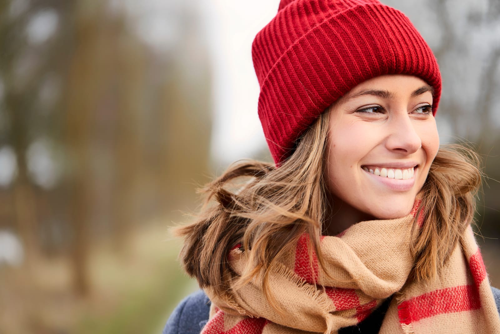 a portrait of a beautiful young woman with a red cap and scarf