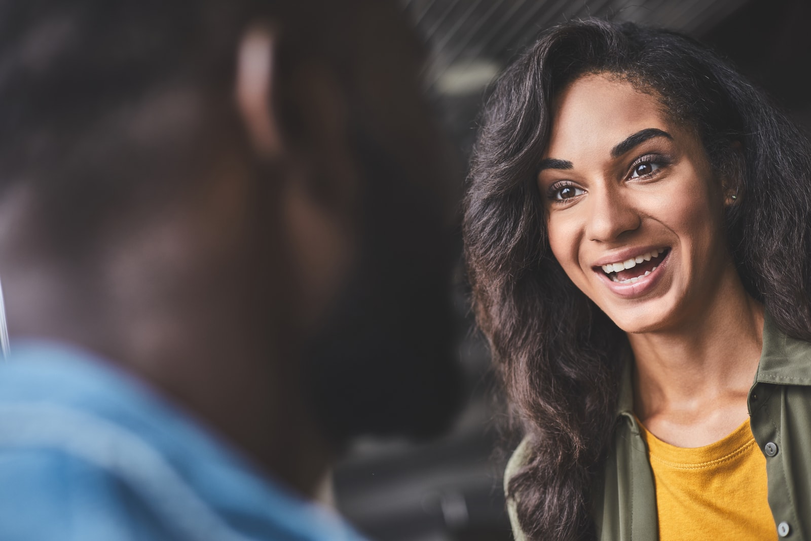a smiling black woman talks to a man