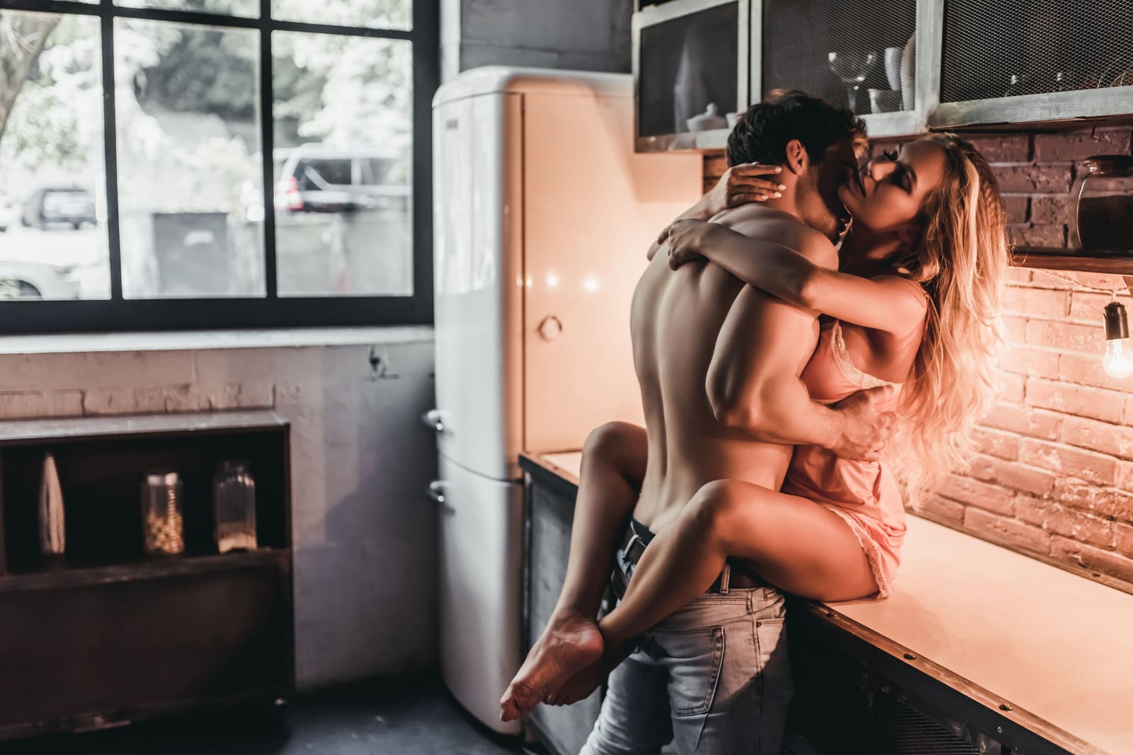 una bella coppia di innamorati fa l'amore sul bancone della cucina