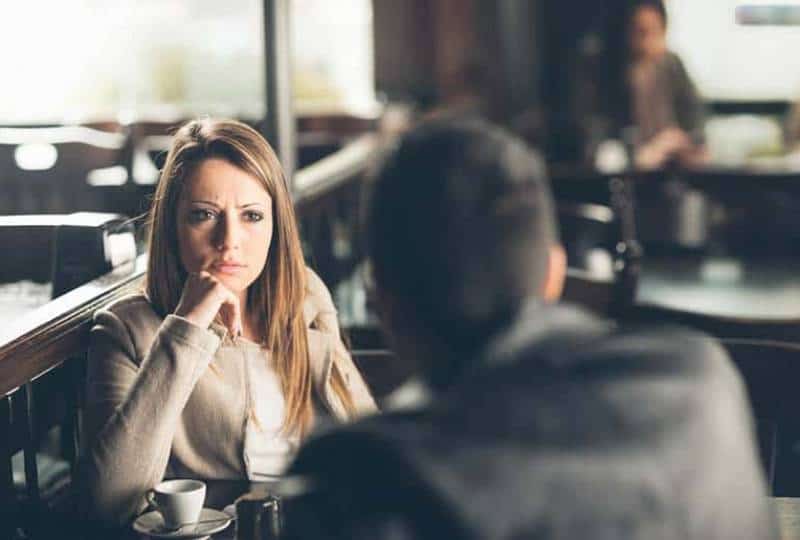 angry woman looking at man in cafe