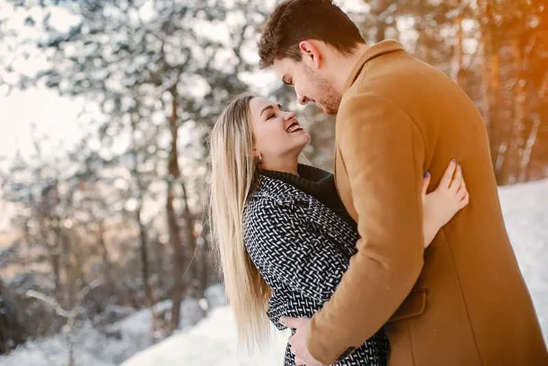 couple in love hugging on snow outdoor