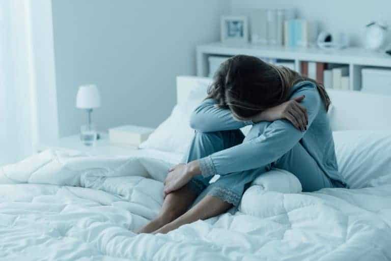 depressed woman sits on the bed