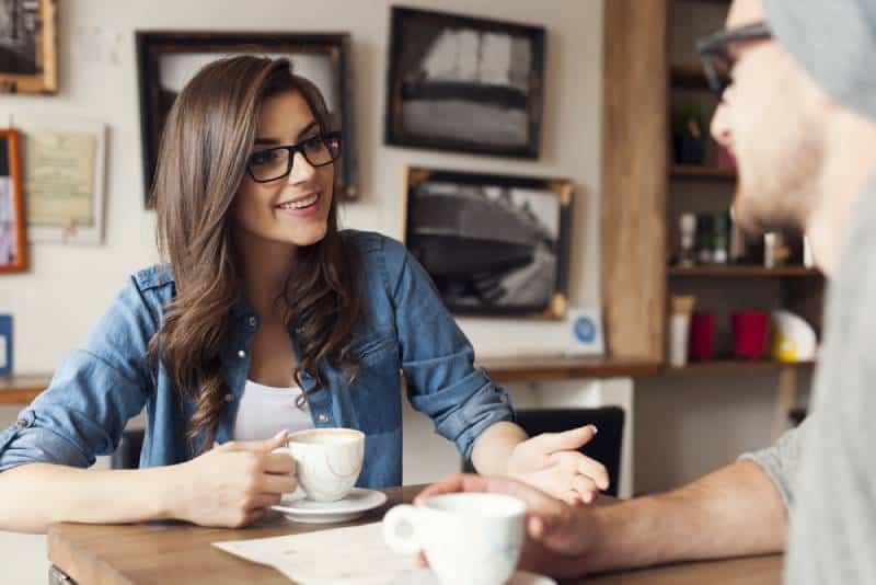 coppia hipster che parla in un caffè