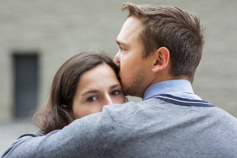 hombre besando a su novia preocupado fuera