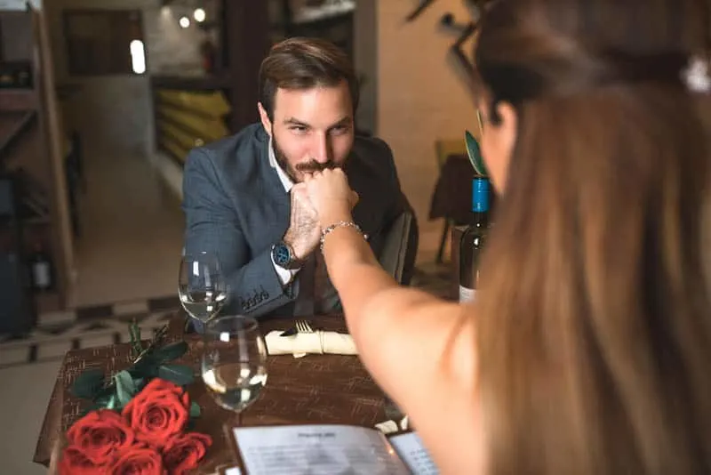 man kissing woman's hand at date