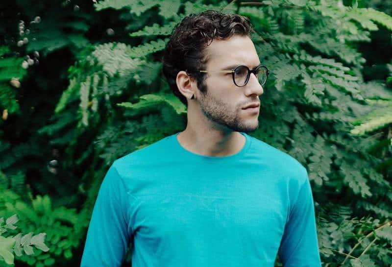 man wearing glasses and blue long sleeve shirt standing outside