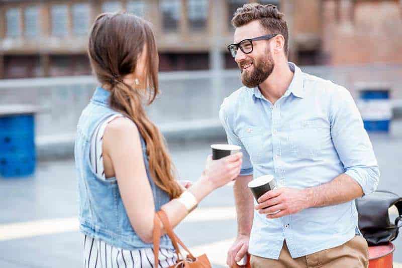 man wearing white shirt talking to woman