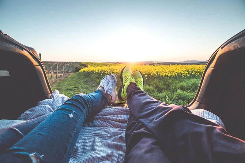 Couple's lying in car enjoying the sunrise