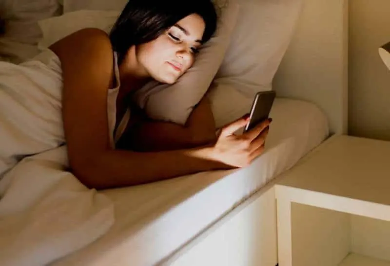 woman typing on her phone before sleep