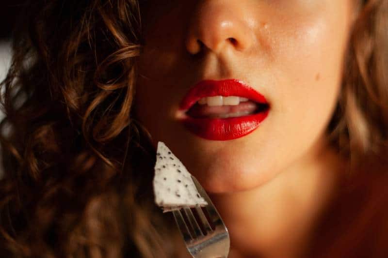 woman with red lipstick holding white and black star ornament