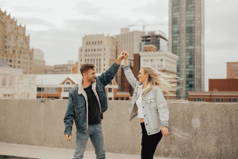 pareja sonriente bailando en una azotea
