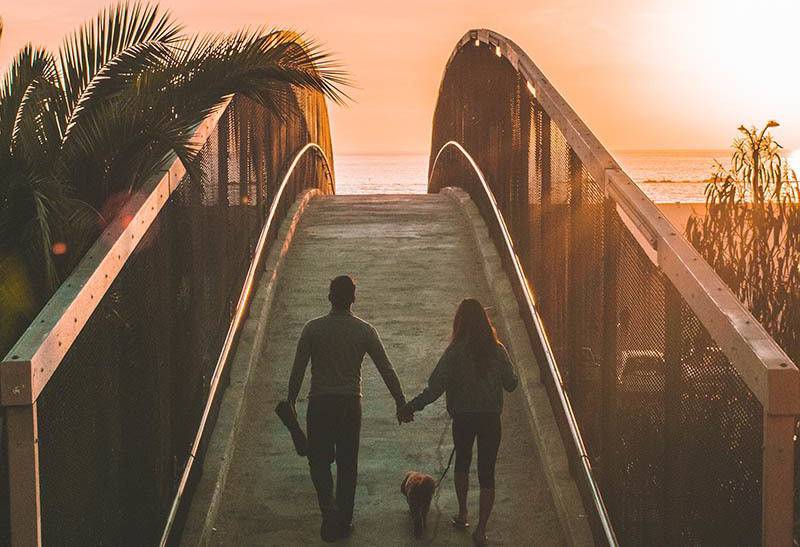 couple holding hands and walking outside