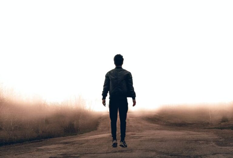 vista traseira de um homem a caminhar sozinho no exterior