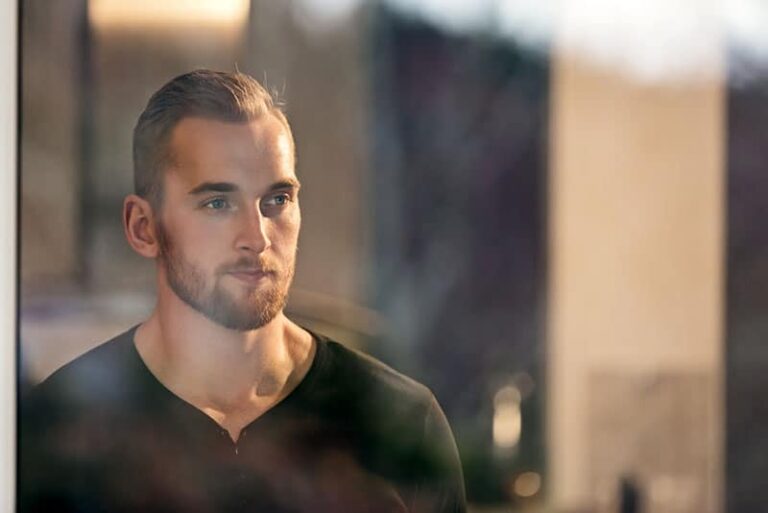 serious man standing by the window