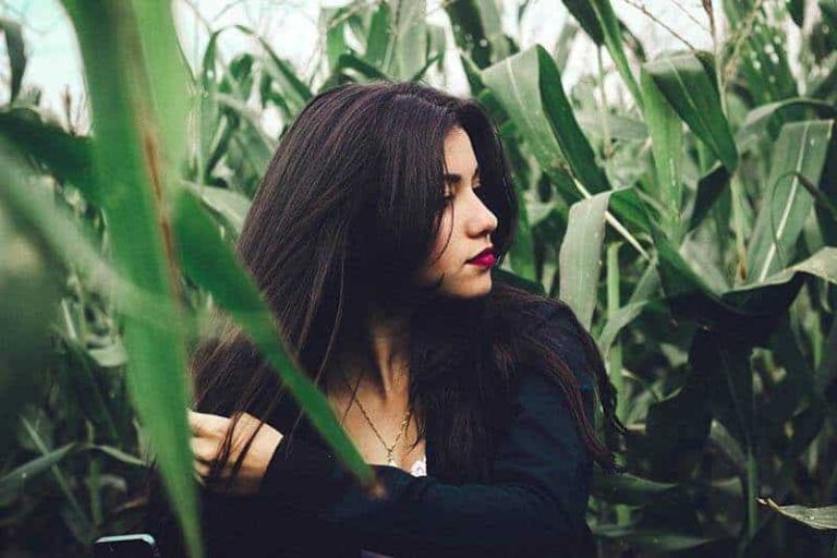 woman surrounded by green leafs