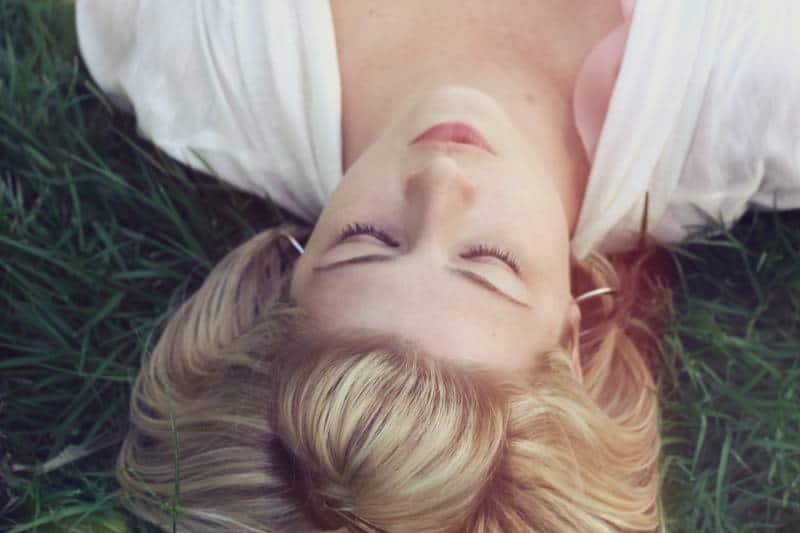 Woman lying on green grasses