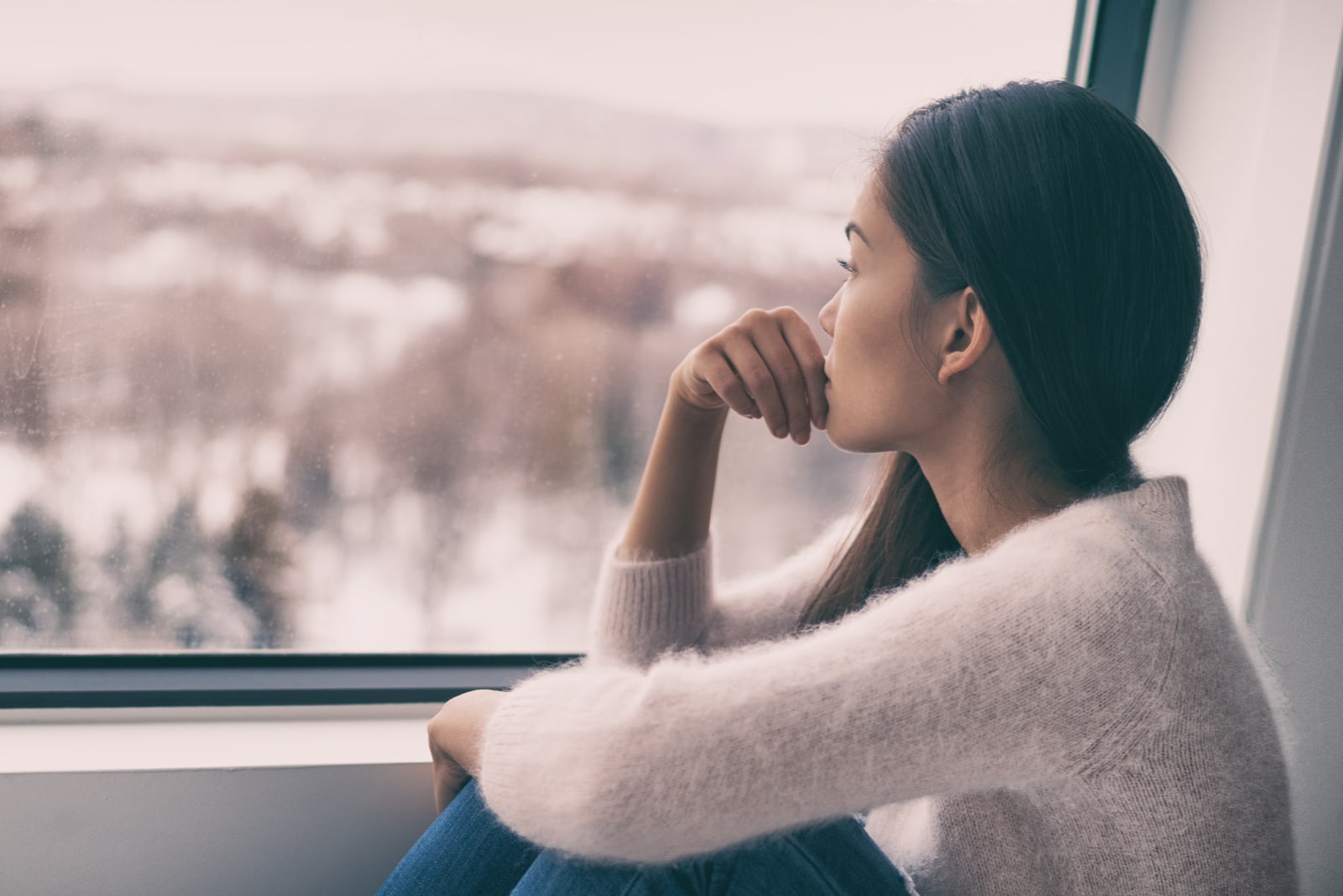 una mujer sentada junto a la ventana