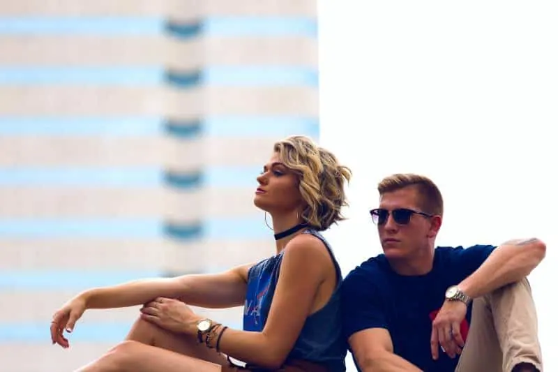 blonde woman with blue dress sits next to man with blue tshirt