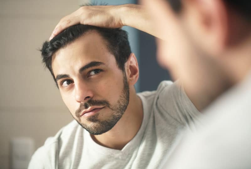 handsome man looking at mirror