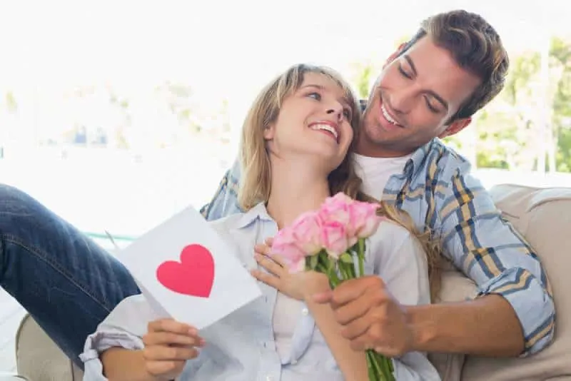 loving couple with flowers and greeting card