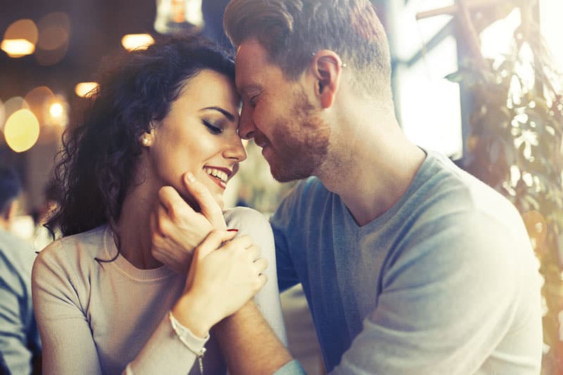 man cuddling womans face