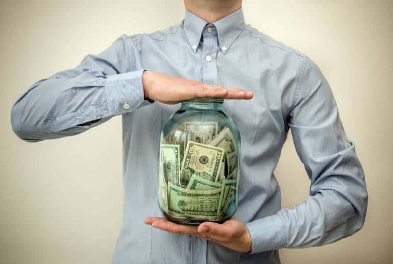 man holding jar full of money