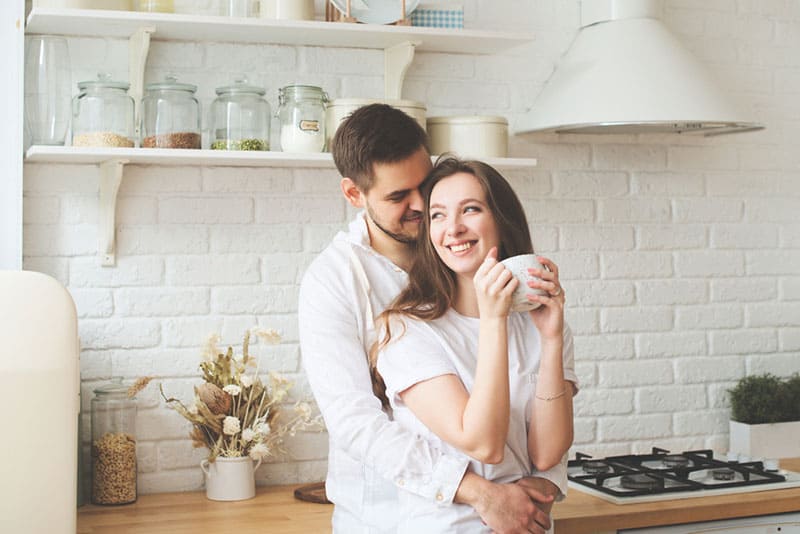 man hugging woman in the kitchen