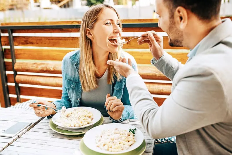 man sharing food with his girlfriend