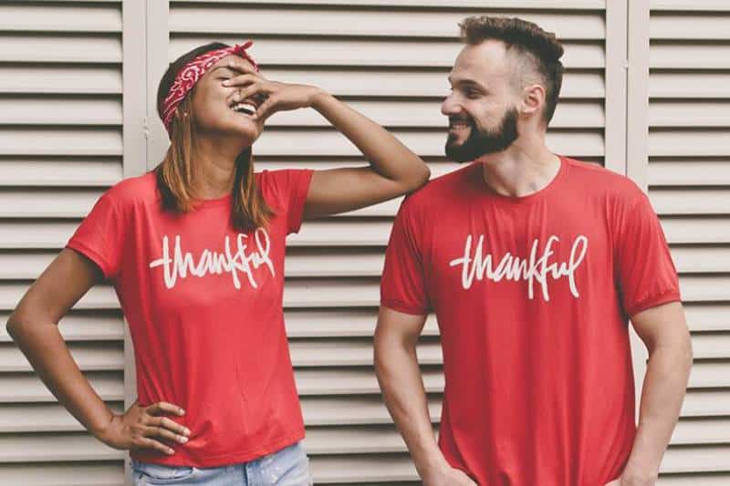 smiling man and woman wearing same shirt
