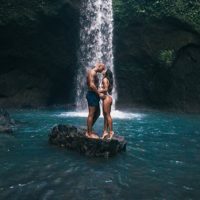 couple kissing beside waterfall