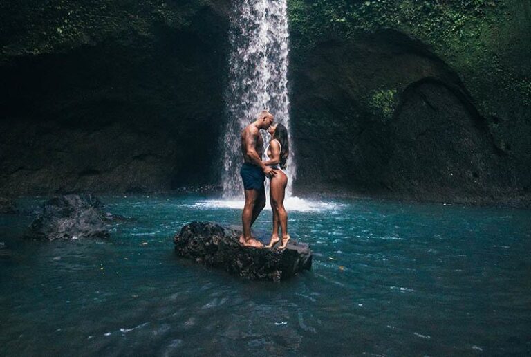 casal a beijar-se junto a uma cascata