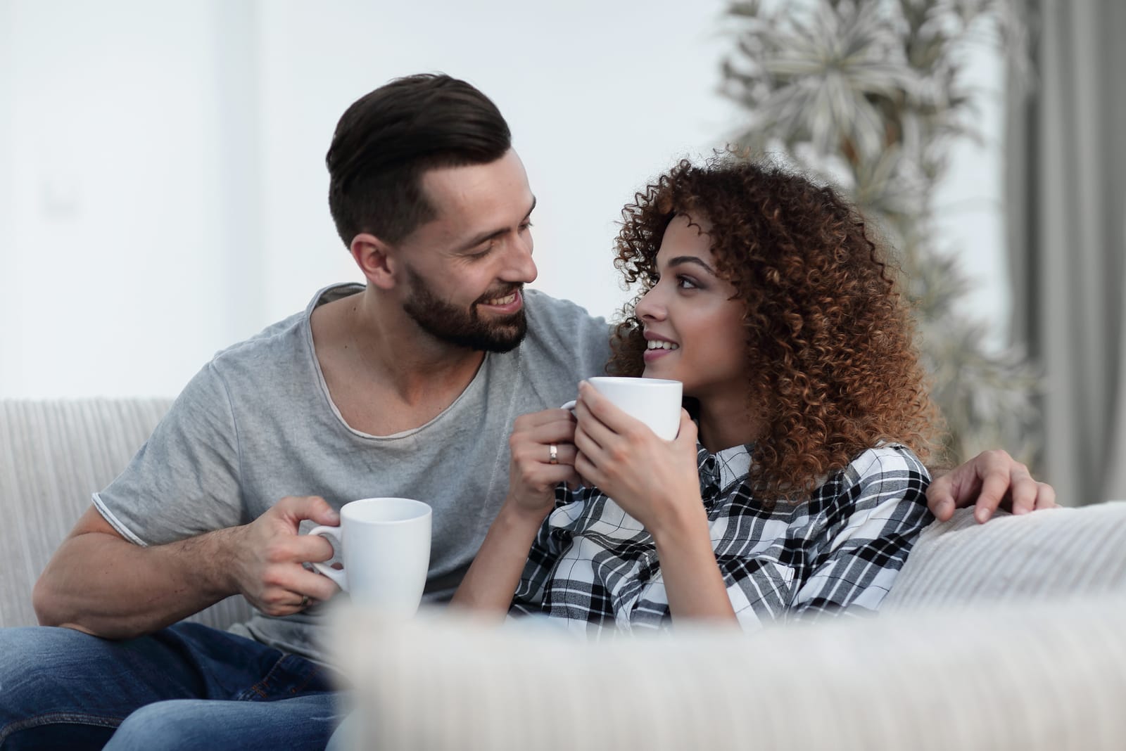 una pareja de enamorados tomando café en el sofá