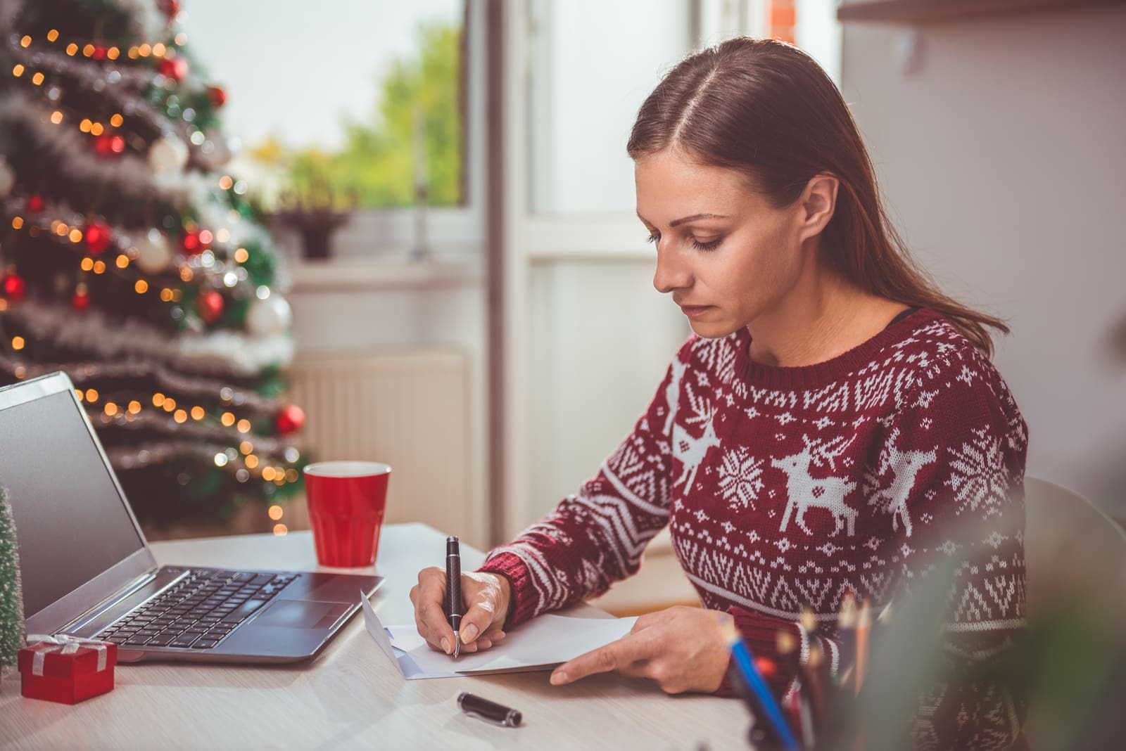 una donna siede al computer portatile e scrive